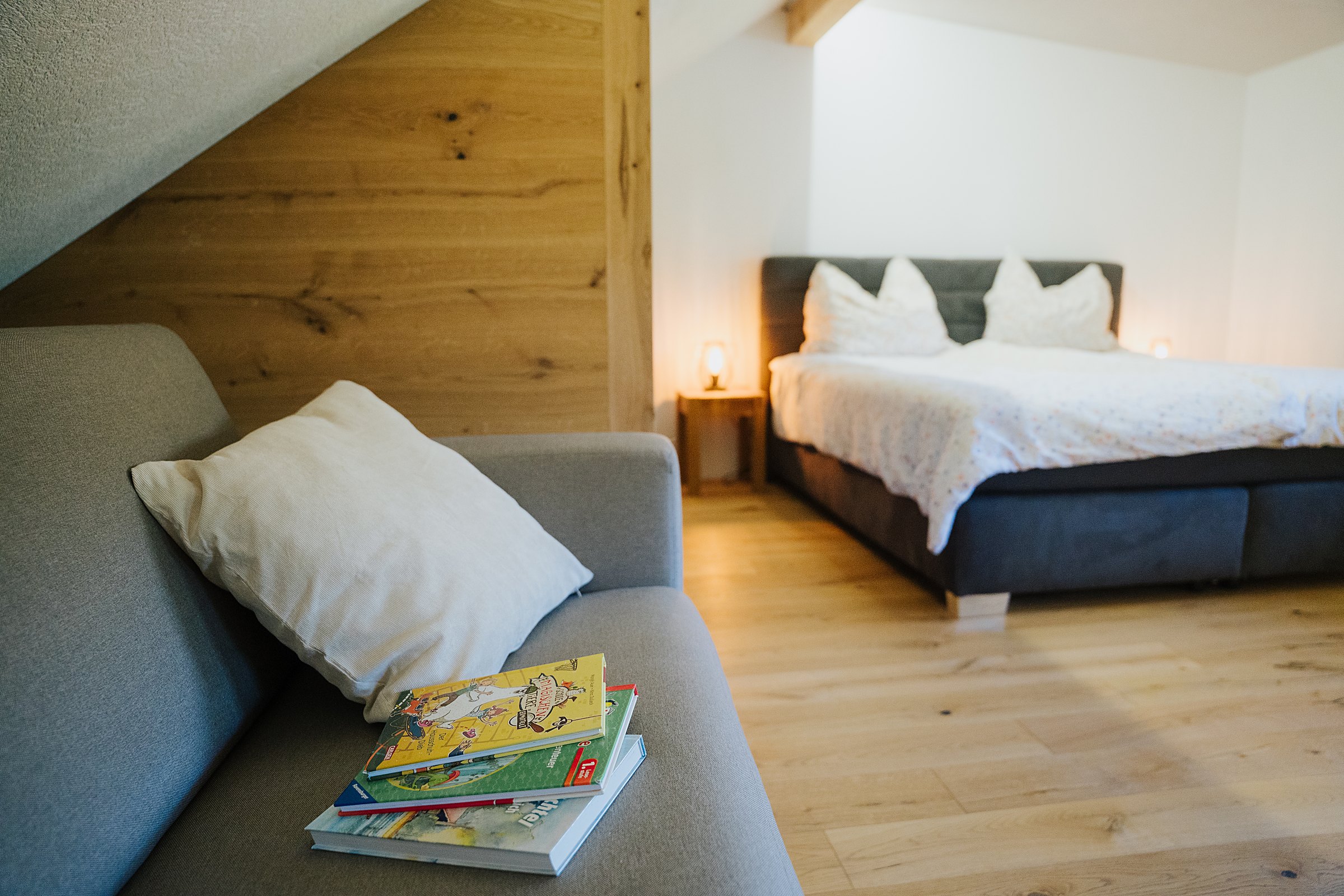 Helles Schlafzimmer mit Holz-Akzentwand und Sitzecke im Ferienhaus Gnesau